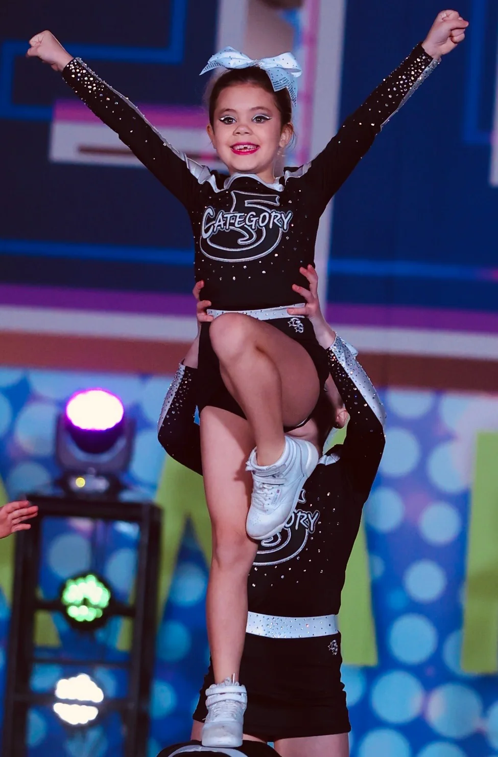 A young Category 5 flyer holding a high stunt at competition